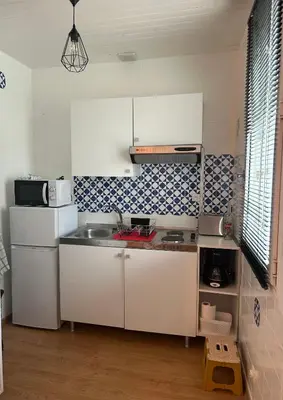 a kitchen with white cabinets and a sink at appartement hyper centre in Narbonne
