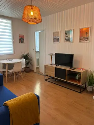 a living room with a flat screen tv and a table at appartement hyper centre in Narbonne