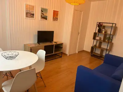 a living room with a white table and blue chairs at appartement hyper centre in Narbonne