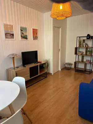 a living room with a television and a table and chairs at appartement hyper centre in Narbonne