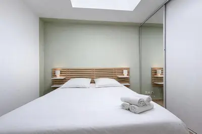 a bedroom with a bed and a large mirror at Les Colonnes - Appartement en duplex - Wifi in Narbonne