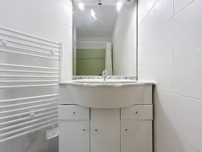 a white bathroom with a sink and a mirror at Les Colonnes - Appartement en duplex - Wifi in Narbonne