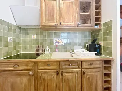 a kitchen with wooden cabinets and a sink at Les Colonnes - Appartement en duplex - Wifi in Narbonne