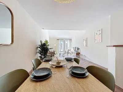 a dining room with a wooden table and chairs at Les Colonnes - Appartement en duplex - Wifi in Narbonne