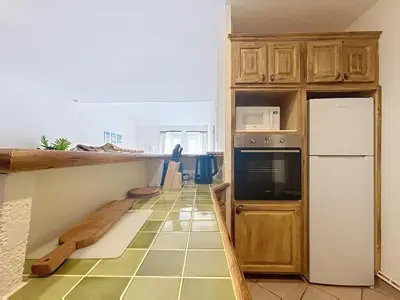 a table with wine glasses and a large mirror at Les Colonnes - Appartement en duplex - Wifi in Narbonne