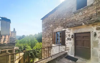 an old stone building with a balcony with a door at Grande Maison De Village in Saint-Vincent