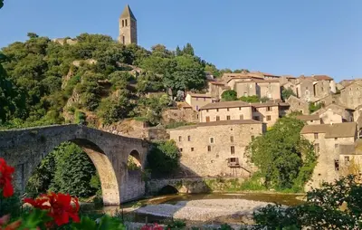 a bridge over a river in front of a village at Grande Maison De Village in Saint-Vincent