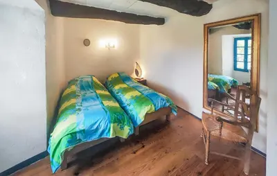 a bedroom with a bed and a mirror and a chair at Grande Maison De Village in Saint-Vincent
