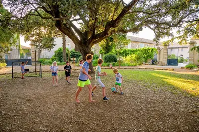 a group of children playing soccer in a park at Domaine de Puychêne in Saint-Nazaire-dʼAude