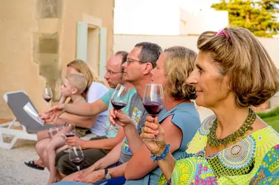a group of people sitting together holding wine glasses at Domaine de Puychêne in Saint-Nazaire-dʼAude