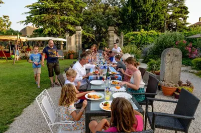 a group of people sitting at a table eating food at Domaine de Puychêne in Saint-Nazaire-dʼAude