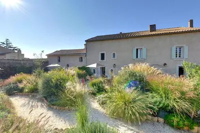 a house with a lot of plants in front of it at Domaine de Puychêne in Saint-Nazaire-dʼAude