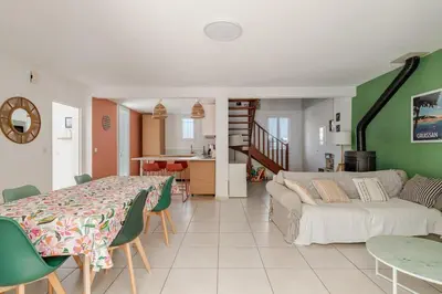 a living room with a bed and a dining table at Maison Gruissan proche du village et de la plage in Gruissan