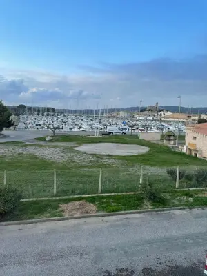 a parking lot with boats in a marina at Maison Gruissan proche du village et de la plage in Gruissan