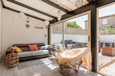 a living room with a couch and a table at Maison Gruissan proche du village et de la plage in Gruissan