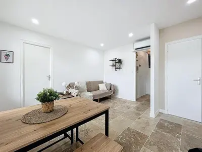 a living room with a table and a couch at Lakanaille - Appartement proche du centre - Wifi et Climatisation in Narbonne