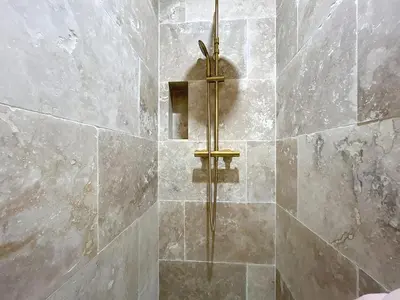 a shower with a brass fixtures in a bathroom at Lakanaille - Appartement proche du centre - Wifi et Climatisation in Narbonne