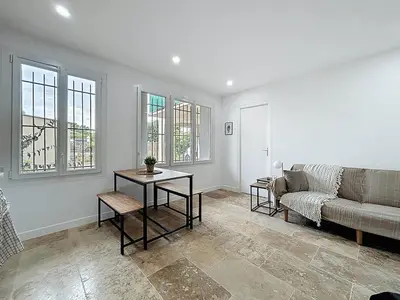 a living room with a couch and a table at Lakanaille - Appartement proche du centre - Wifi et Climatisation in Narbonne