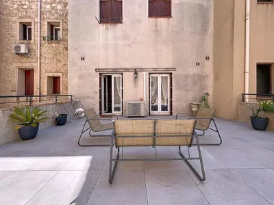 a group of chairs sitting on a patio at Le Patio - Grande Terrasse - Wifi et Climatisation in Narbonne