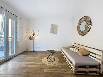 a living room with a couch and a mirror at Le Patio - Grande Terrasse - Wifi et Climatisation in Narbonne