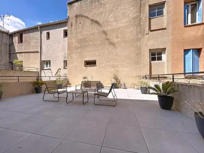 a patio with a table and chairs in front of a building at Le Patio - Grande Terrasse - Wifi et Climatisation in Narbonne