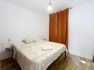 a bedroom with a bed with a brown curtain at Le Patio - Grande Terrasse - Wifi et Climatisation in Narbonne