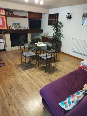 a living room with a table and chairs and a couch at jolie appartement en rez de chaussée in Quillan