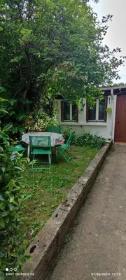 a house with a table in the grass next to a house at jolie appartement en rez de chaussée in Quillan