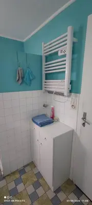 a bathroom with a toilet and a blue wall at jolie appartement en rez de chaussée in Quillan