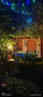 a table and chairs in a yard at night at jolie appartement en rez de chaussée in Quillan