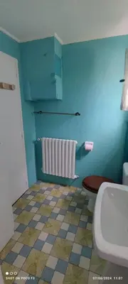 a bathroom with a toilet and a blue wall at jolie appartement en rez de chaussée in Quillan