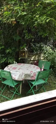 two green chairs and a table in the grass at jolie appartement en rez de chaussée in Quillan