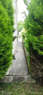 a sidewalk next to a building with trees at jolie appartement en rez de chaussée in Quillan