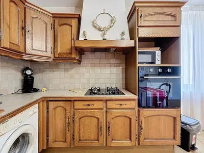 a kitchen with wooden cabinets and a stove top oven at Le Luxembourg - Appartement proche des Halles - Wifi in Narbonne