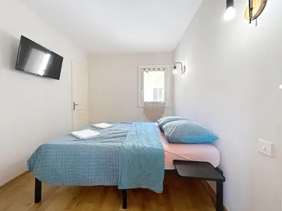 a bedroom with a bed and a tv on the wall at Le Luxembourg - Appartement proche des Halles - Wifi in Narbonne