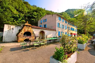 a building with a table and chairs in a courtyard at Auberge de jeunesse La Forge in Quillan