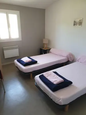 a room with two beds and a window at Auberge de jeunesse La Forge in Quillan