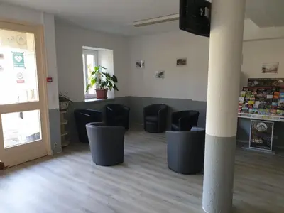 a waiting room with black chairs and a door at Auberge de jeunesse La Forge in Quillan