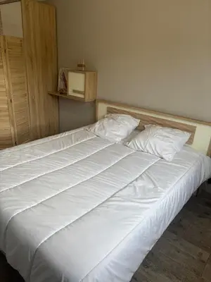 a bed with white sheets and pillows in a room at Maison 95m2 6 personnes piscine in Narbonne