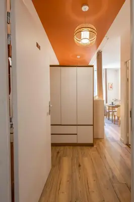 an open living room with white cabinets and wood floors at Le Sirocco - Studio Confort Lit Queen Size in Mazamet
