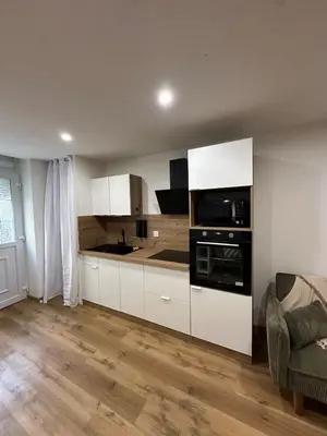 a kitchen with white cabinets and a stove top oven at Petite maison cosy rénovée, entre mer et vignobles in Ouveillan