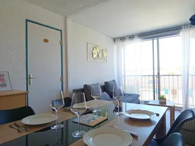 a dining room with a table with wine glasses at La Vie en Rose Cosy Proche du Port in Gruissan