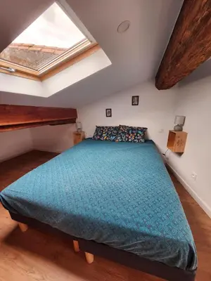 a bedroom with a large bed in a attic at T3 Duplex with bike garage close in Castelnaudary