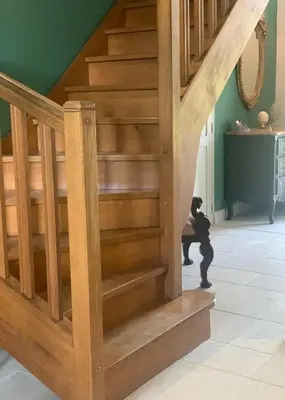 a wooden staircase in a house with a person walking up the stairs at La Bastide De Negra in Montesquieu-Lauragais