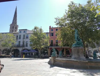 a fountain in a square in a city with buildings at Proche Carcassone chambre avec salle de bain et WC privée Piscine salon et kitchenette partagés avec voyageurs in Cépie