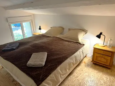 a bedroom with a large bed with two towels on it at Proche Carcassone chambre avec salle de bain et WC privée Piscine salon et kitchenette partagés avec voyageurs in Cépie
