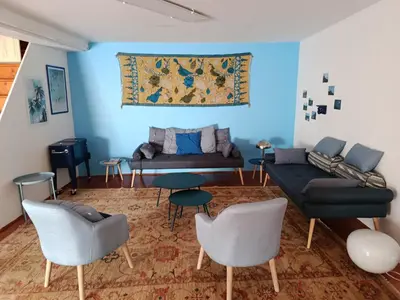 a living room with blue walls and a couch and chairs at Proche Carcassone chambre avec salle de bain et WC privée Piscine salon et kitchenette partagés avec voyageurs in Cépie