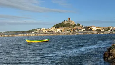 a yellow boat in the middle of a body of water at Voilier à quai in Gruissan