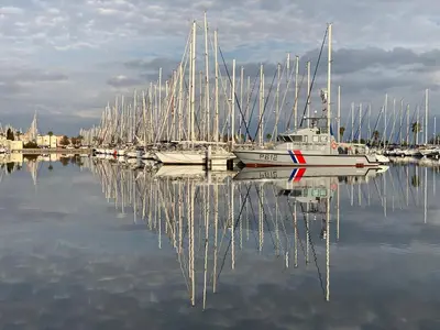 a group of boats are docked in a marina at Voilier à quai in Gruissan