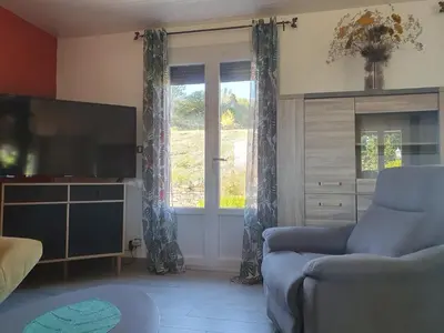 a living room with a couch and a television at Le Gîte Sambacacia in Montazels
